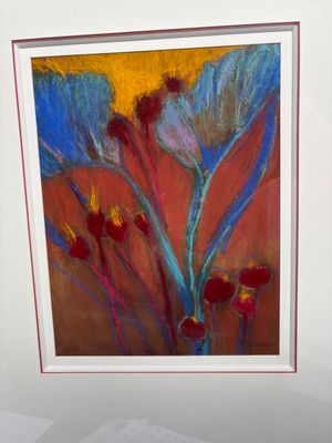 tableau représentant un tableau de fleurs dans un cadre blanc posé sur une table
