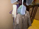 un porte-manteau sur lequel sont suspendus des vêtements, dans un couloir