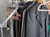 a lot of clothes hanging on a rack in a room
