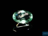 a close up of a green gemstone on a black surface