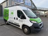 a white and green van parked in front of a building
