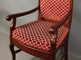 an old wooden chair with red and white patterned upholstered upholstered seat