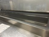 a metal counter top with a glass door and a sticker on it