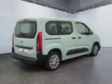 the rear of a green van is parked in a garage