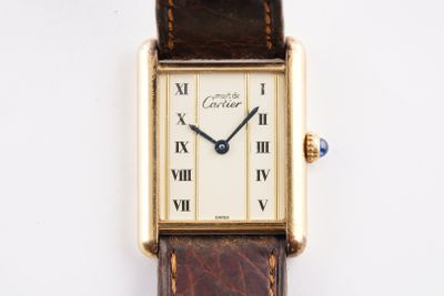 une image d'un gros plan d'une montre-bracelet avec des chiffres romains