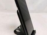 a close up of a cell phone on a stand on a white surface