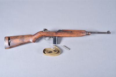 an old rifle is laying on a table next to a ribbon