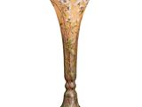 un vase orné de fleurs, posé sur une surface blanche