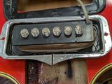 a close up of a red guitar with four knobs