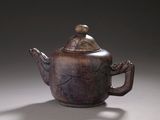 a brown teapot with a lid on a table