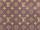 a close up of a brown and white louis vuitto bag