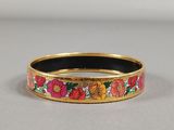 un gros plan sur un bracelet en or orné de fleurs