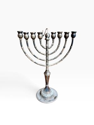 a metal menorah with five candles on a white background