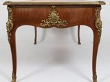 a small wooden table with a gold decoration on it