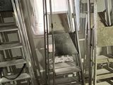trois échelles dans une pièce, avec une fenêtre en arrière-plan