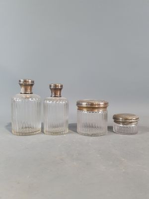 three glass jars with silver lids and a silver lid
