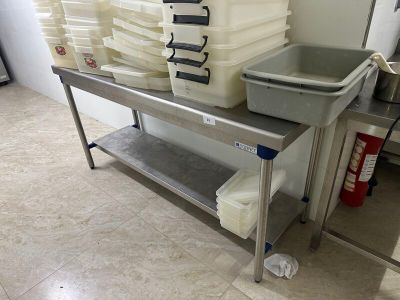 une table en métal sur laquelle sont posés plusieurs récipients en plastique