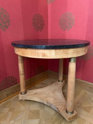 une table en bois avec un plateau noir dans une pièce
