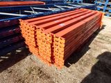 orange and blue steel beams stacked on top of each other in a yard