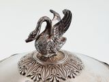 a silver plate with a bird on top of it
