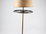 a black lamp with a beige shade on top of it