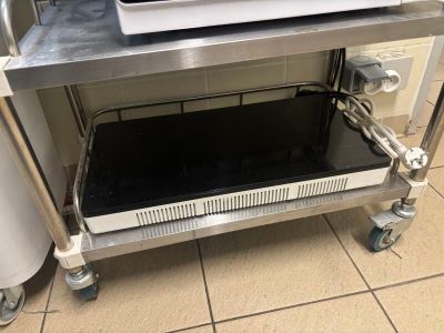 a microwave that is sitting on a cart in the kitchen