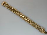 gros plan d'un bracelet en or sur une surface blanche