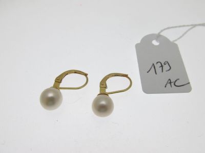 une paire de boucles d'oreilles en perles et une étiquette de prix posée sur une table