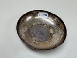 a silver plate with a coin on it sitting on a table