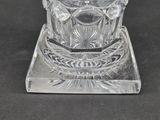 a clear glass candle holder on a black surface
