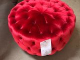 un pouf rond rouge posé à même le sol dans un magasin