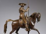 bronze statue of a man riding a horse with a spear in his hand