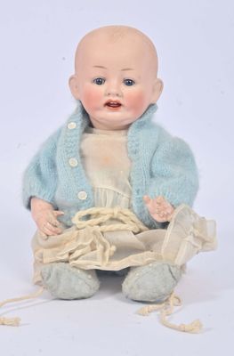 a baby doll that is sitting on the ground