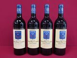 three bottles of red wine are lined up on a pink surface