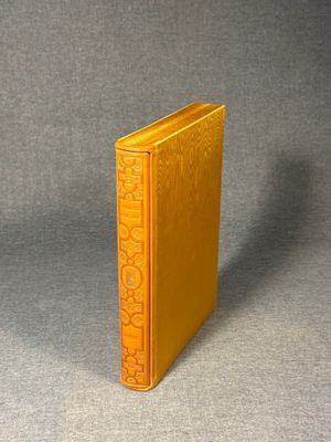 an old yellow book sitting on top of a gray surface