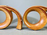 deux sculptures en bois représentant un motif en spirale sur une surface grise