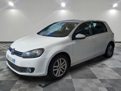 the white volkswagen golf is parked in a room with a checkered floor