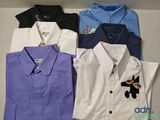 Quatre chemises de couleurs différentes sont alignées sur une étagère
