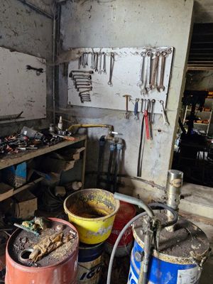Plusieurs seaux remplis d'outils sont posés sur une table dans un garage.