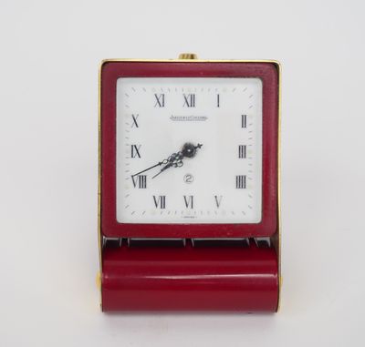a small red clock with roman numerals on it