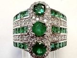 an image of a close up of a ring with emeralds and diamonds