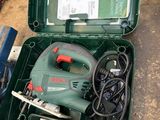 une boîte verte posée par terre, contenant des outils