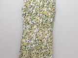 a yellow and white floral dress hanging on a hanger