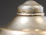 an antique silver plated glass jar with a lid on a table