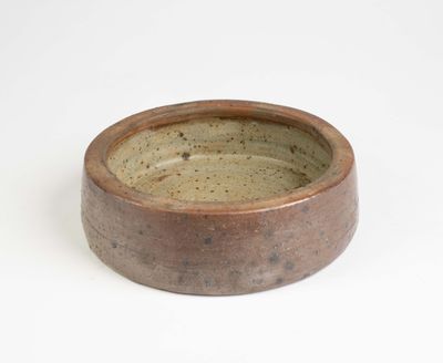 un bol marron avec un bord marron sur un fond blanc