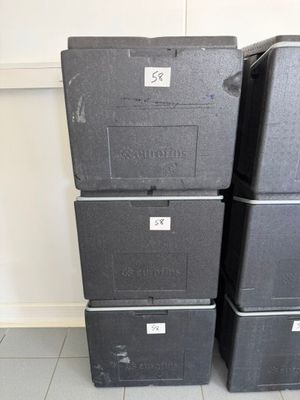 three black boxes are stacked on top of each other in a room