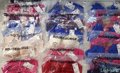 many bags of clothes that are on display in a store
