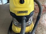 un gros plan d'un aspirateur jaune et noir posé sur un sol carrelé