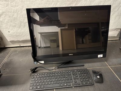 un écran d'ordinateur, un clavier et une souris posés par terre