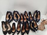 several pairs of women ' s shoes are lined up on a white surface
